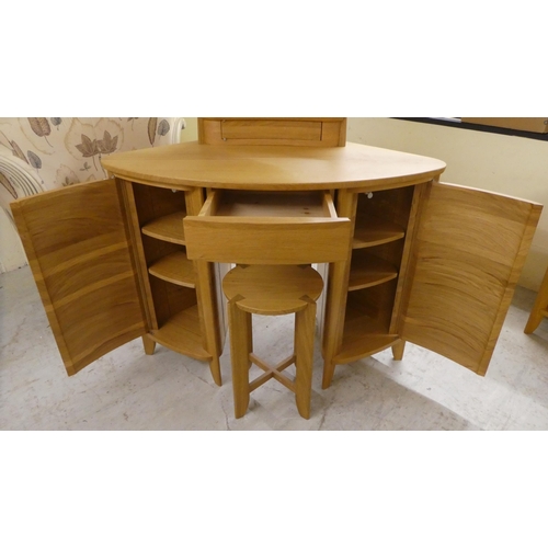 77 - A modern light oak dressing table, surmounted by an oval mirror and single drawer base, over two ped... 