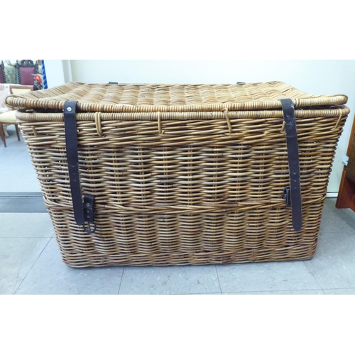 376 - A wicker hamper with hide straps and a hinged lid  22