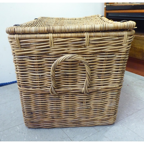 376 - A wicker hamper with hide straps and a hinged lid  22