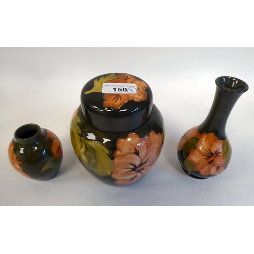 150 - A Moorcroft pottery ginger jar and cover; and two vases, decorated in Hibiscus pattern, on a green b... 