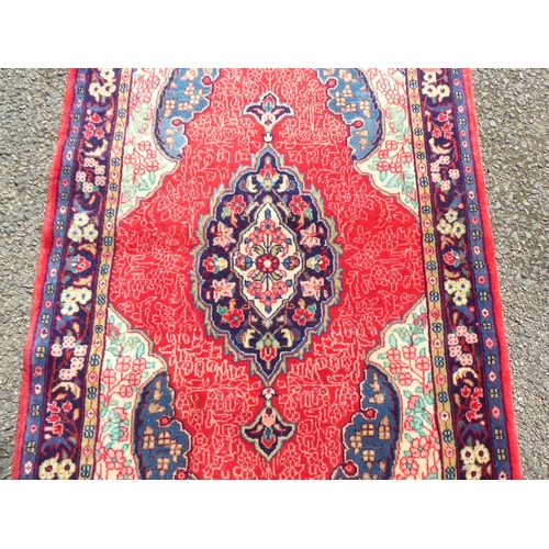 156 - A Persian rug, decorated with a central gul and floral borders, on a red ground  52