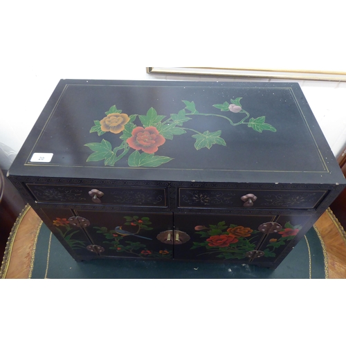 20 - A modern Chinese black lacquered and overpainted table-top cabinet with two drawers, over two panell... 