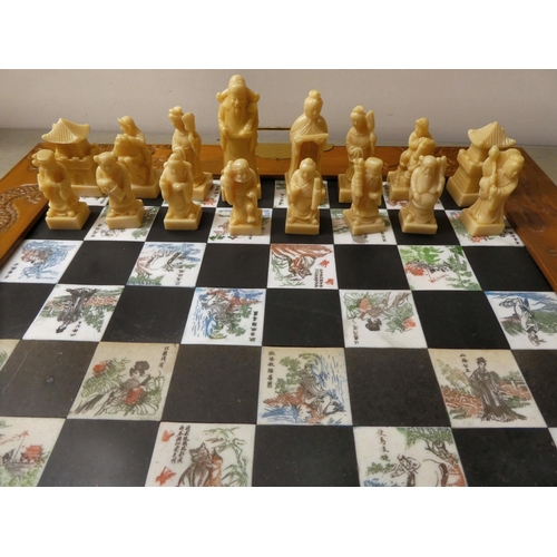 204 - A Oriental style resin chess set, in a fold-out board carrying case, set dragon carved carrying case... 