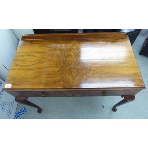 25 - A 1930s walnut two drawer side table, raised on cabriole legs  31.5