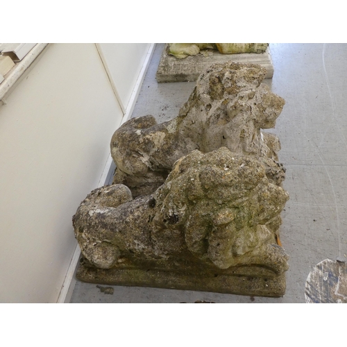 33 - A pair of composition stone garden statues, recumbent lions  21