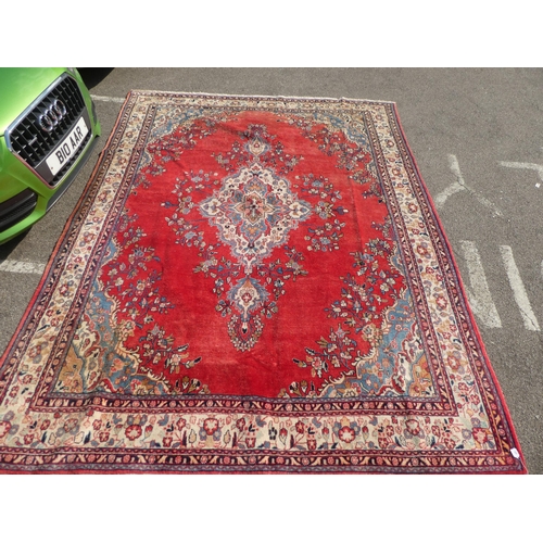 345 - A Persian carpet, decorated with a central medallion, bordered by a floral design, on a multi-colour... 