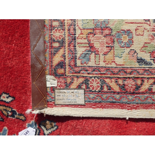 345 - A Persian carpet, decorated with a central medallion, bordered by a floral design, on a multi-colour... 