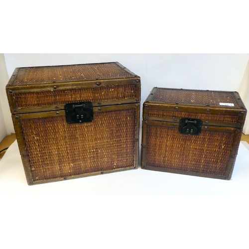 35 - Two similar rattan clad boxes, each with opposing metal handles  largest 12