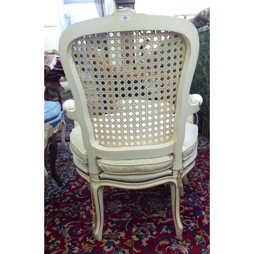 53 - A modern cream painted and upholstered bedroom chair with a caned back, raised on cabriole legs