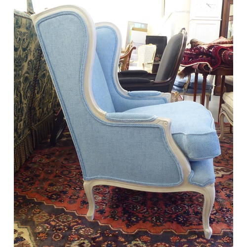 59 - A modern cream painted, blue upholstered arm chair, raised on cabriole legs