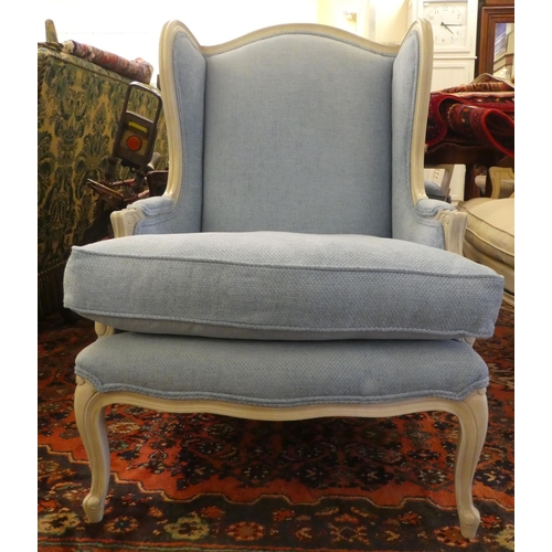 59 - A modern cream painted, blue upholstered arm chair, raised on cabriole legs