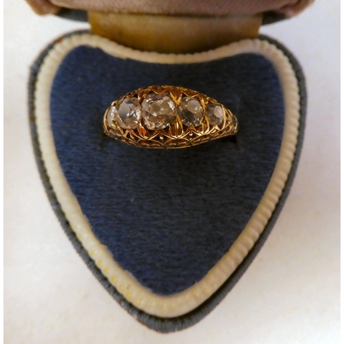 63 - A Victorian gold and black enamel, blue diamond ring, set with five graduated stones, on scrolled sh... 