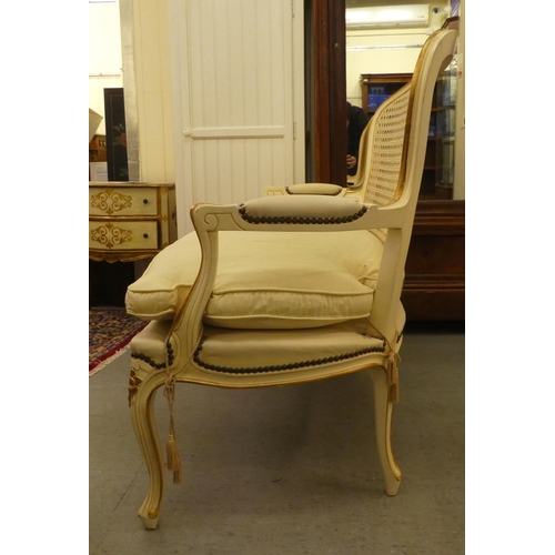 64 - A modern cream and gilt painted two person salon settee, raised on cabriole legs  49