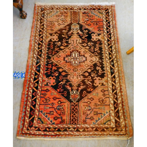 67 - A Persian rug with floral motifs, on a terracotta ground  35