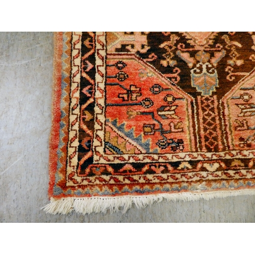 67 - A Persian rug with floral motifs, on a terracotta ground  35