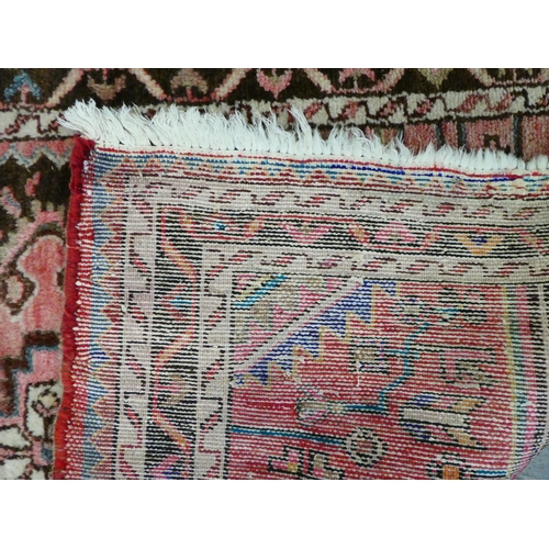 67 - A Persian rug with floral motifs, on a terracotta ground  35