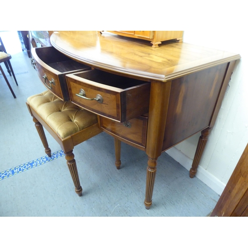 7 - A modern yew finished bowfront dressing table, raised on turned, reeded legs  30