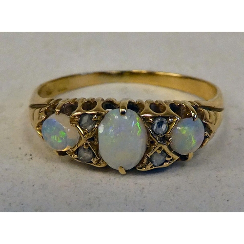 74 - An 18ct gold ring, set with three cabochon opals and four diamonds