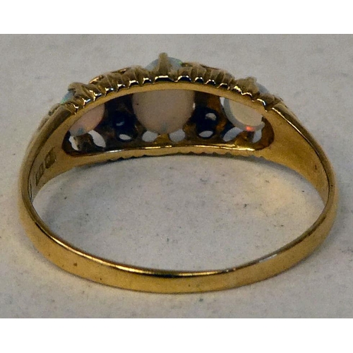 74 - An 18ct gold ring, set with three cabochon opals and four diamonds