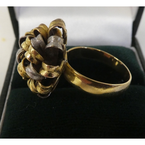 78 - A bi-coloured gold ring of floral design, fashioned as interlocking ribbons  stamped 18k, Spain... 