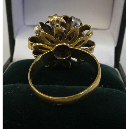 78 - A bi-coloured gold ring of floral design, fashioned as interlocking ribbons  stamped 18k, Spain... 