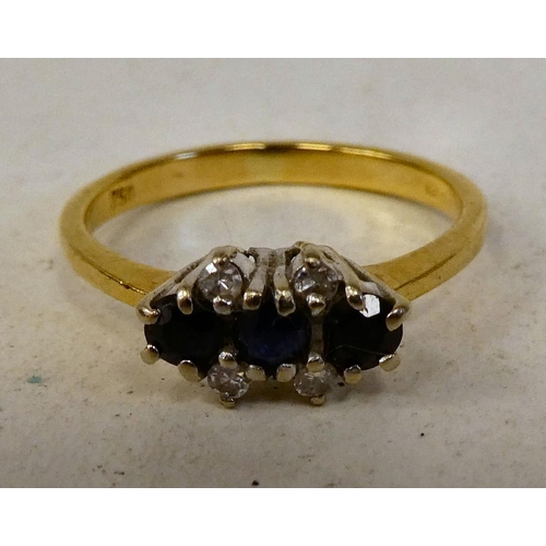 82 - An 18ct gold ring, set with three sapphires, flanked with four diamonds