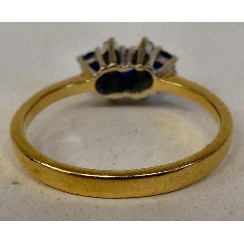 82 - An 18ct gold ring, set with three sapphires, flanked with four diamonds