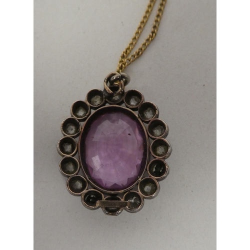 85 - A fine yellow metal neckchain with a white metal pendant, hosting a pink central stone, surrounded b... 