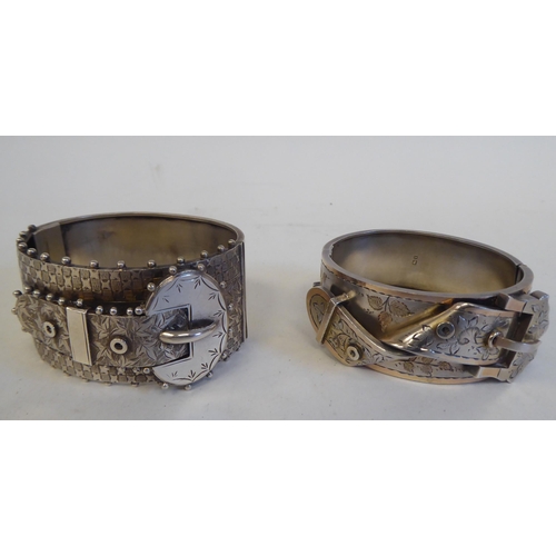 89 - Two dissimilar belt buckle design, hinged silver/white metal bracelets  mixed marks