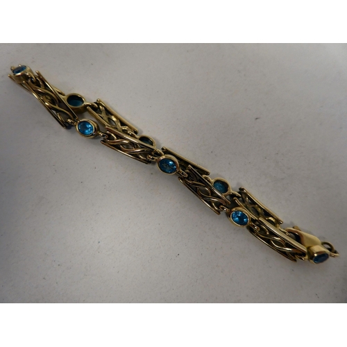 92 - A 9ct gold bracelet with eight rubover set blue topaz