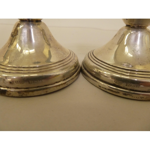 357 - Silver collectables, viz. a pair of dwarf candlesticks; and two dissimilar napkin rings  mixed ... 