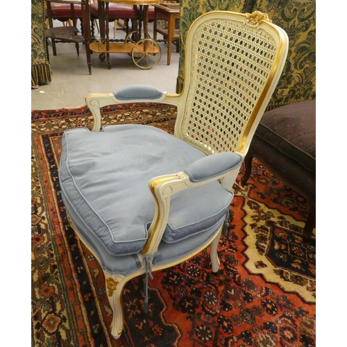 44 - A modern cream painted, blue upholstered bedroom chair with a caned back, raised on cabriole legs