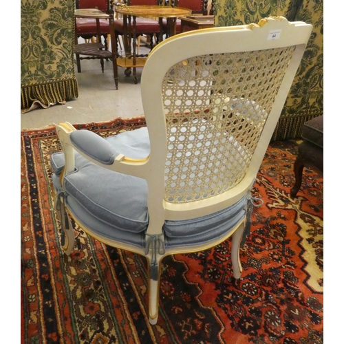 44 - A modern cream painted, blue upholstered bedroom chair with a caned back, raised on cabriole legs