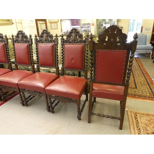 45 - A set of six 1920/30s baronial style oak framed dining chairs, each with an ornately carved crest, o... 