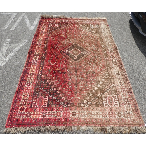 66 - A Persian rug with floral motifs, on a red ground  60