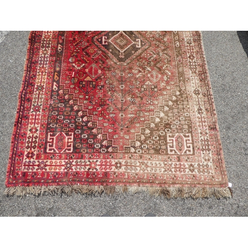 66 - A Persian rug with floral motifs, on a red ground  60