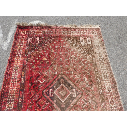 66 - A Persian rug with floral motifs, on a red ground  60