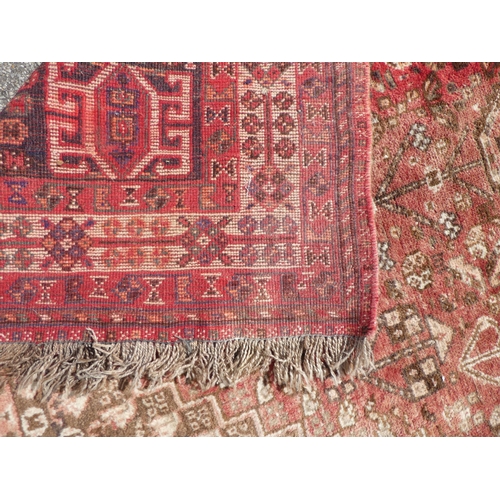 66 - A Persian rug with floral motifs, on a red ground  60