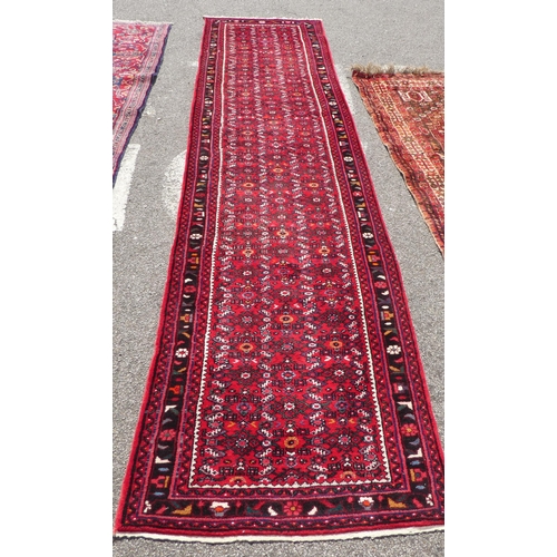 68 - A Persian runner with floral motifs, on a red ground  150