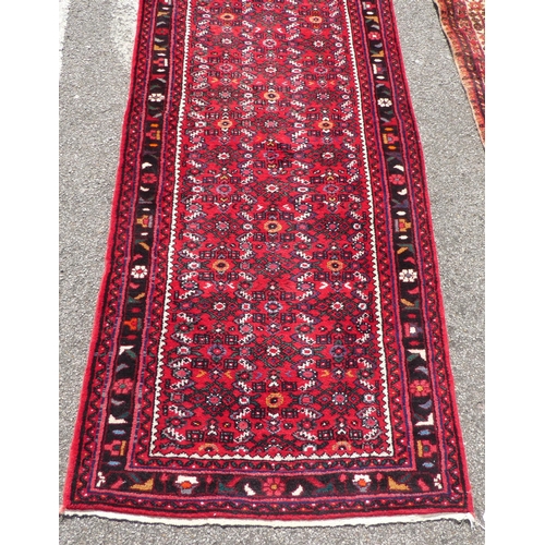 68 - A Persian runner with floral motifs, on a red ground  150