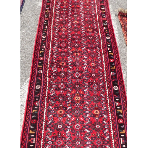 68 - A Persian runner with floral motifs, on a red ground  150