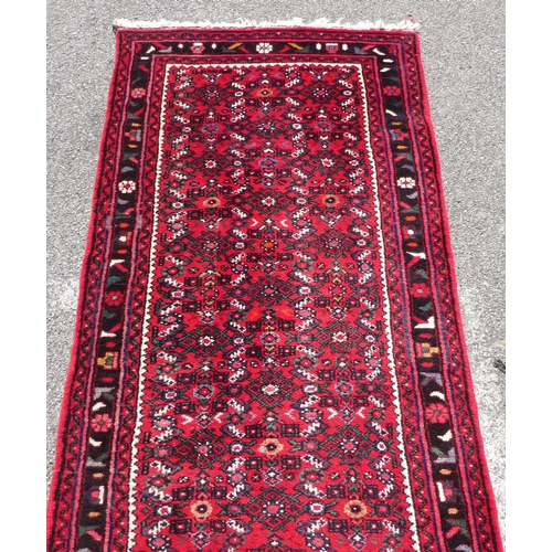 68 - A Persian runner with floral motifs, on a red ground  150