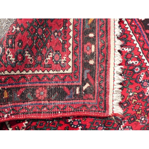 68 - A Persian runner with floral motifs, on a red ground  150