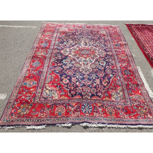 70 - An Iranian Tabriz rug with floral motifs, on a red ground  115