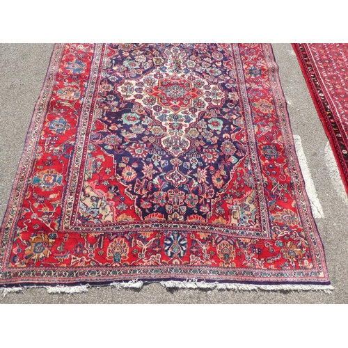 70 - An Iranian Tabriz rug with floral motifs, on a red ground  115