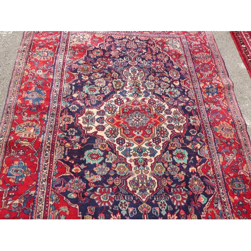 70 - An Iranian Tabriz rug with floral motifs, on a red ground  115