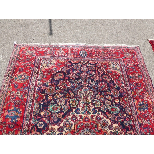 70 - An Iranian Tabriz rug with floral motifs, on a red ground  115