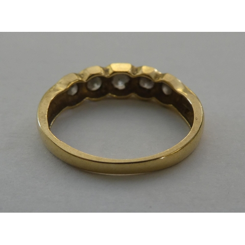 87 - An 18ct gold rubover ring, set with five diamonds