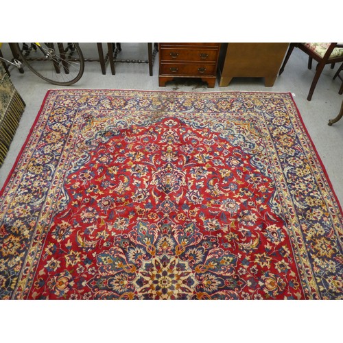 27 - An Isfahan woollen carpet, decorated with floral designs, on a red ground  148