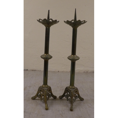 10 - A pair of Art Nouveau brass pricket candlesticks, on a pierced, splayed tripod plinths  21